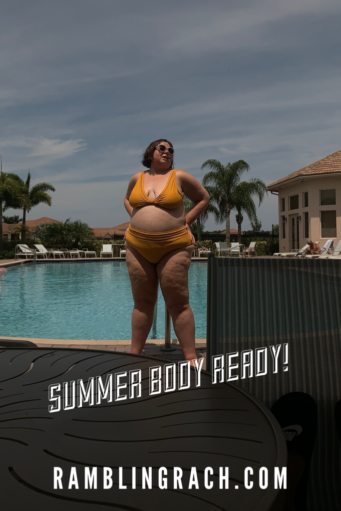 Rambling Rach is standing by the pool in a mustard colored plus size bikini.